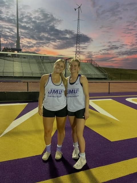 Two players on the purple turf at dusk