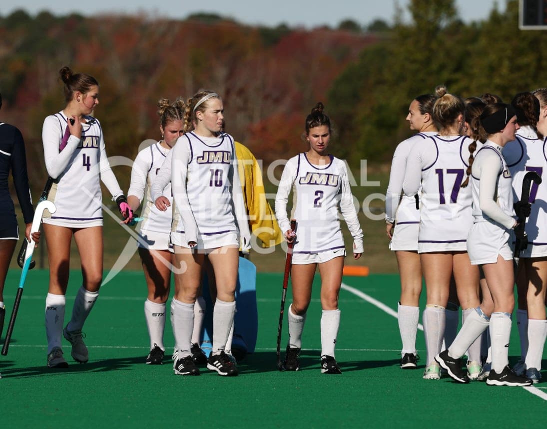 The team in a huddle in white kit